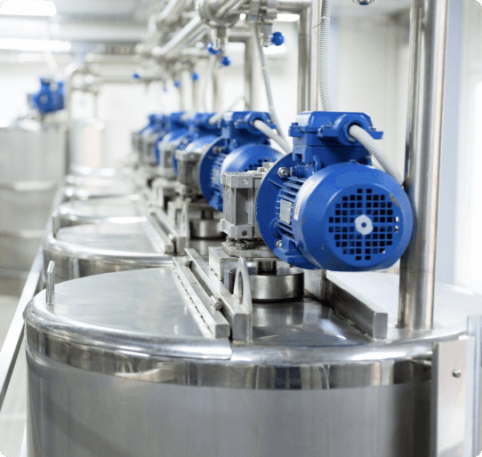 Machinery with steel tanks and blue motors in an industrial setting.